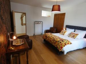 Le Clos De Quintaine Chambres d'Hôtes في Clessé: غرفة في الفندق مع سرير وطاولة مع منضدة sidx