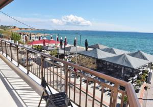 a boardwalk with tables and umbrellas on the beach at Studio Orestis in Nea Moudania