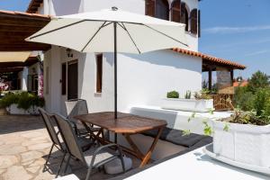 a table and chairs with an umbrella on a patio at Cielle Epoque in Pefkohori