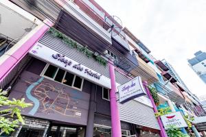 a building with a sign on the side of it at Sleep Dee Hostel in Bangkok