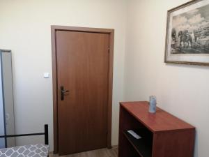 Cette chambre dispose d'une porte en bois et d'une commode en bois. dans l'établissement Hostel Lisięcice, à Lisiecice
