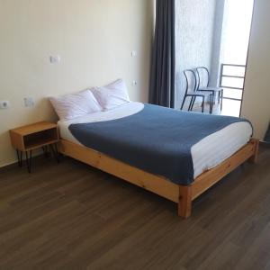 a bedroom with a bed with a blue blanket and a table at Halle Hotel Lalibela in Lalibela