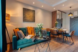 salon z niebieską kanapą i stołem w obiekcie Veronese Apartments by LoftAffair w Krakowie