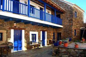 un edificio de ladrillo con puertas azules y un patio en CASA CAMARGA en Santiago Millas