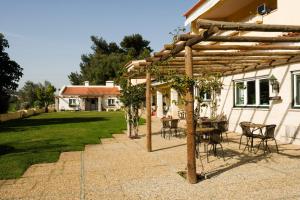 a patio with a table and chairs under a wooden pergola at Lisbon Country Villa in Oeiras +30 photos