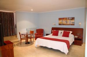 a bedroom with a bed and a table with a chair at Hotel Suís in Sant Celoni