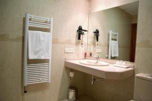 ein Bad mit einem Waschbecken und einem Spiegel in der Unterkunft Hotel Suís in San Celoni