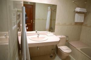 ein Badezimmer mit einem Waschbecken, einem WC und einem Spiegel in der Unterkunft Hotel Suís in San Celoni