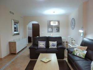 - un salon avec un canapé et une table dans l'établissement Beautiful apartment in a private community., à Ayamonte