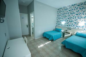 a room with two beds and a tv in it at Hostal La Despensa de Extremadura in Plasencia