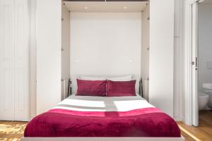 een slaapkamer met een groot bed met rode kussens bij WHome | Alcântara Smart Studio in Lissabon