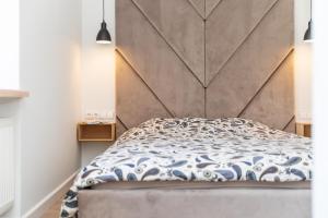 a bedroom with a bed with a large headboard at MARIUS 11 APARTMENT, By Cohost in Palanga