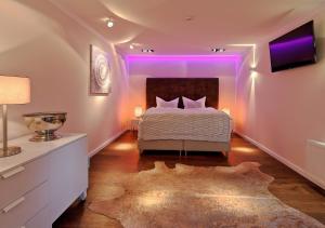 a bedroom with a large bed with purple lighting at Thiel Apartments in Krefeld