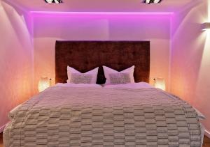 a bedroom with a large bed with purple lighting at Thiel Apartments in Krefeld +5 photos
