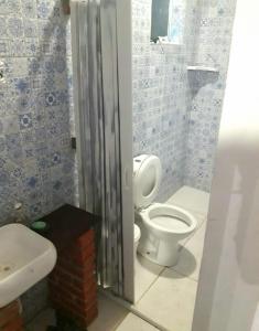 a bathroom with a toilet and a sink at Chácara a 450mt da Praia Boracéia piscina infantil e outra adulto in São Sebastião