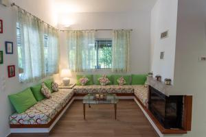 - un salon avec un canapé et une cheminée dans l'établissement Corinthian Villas Orange Villa, à Vrahati