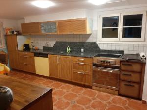 a kitchen with wooden cabinets and a black counter top at Panorama Jurte Über Dem Uri-See A in Sisikon