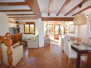 a dining room and living room with a table and chairs at Casa Arenal in Jávea