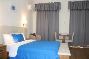 - une chambre avec un lit bleu, une table et des chaises dans l'établissement Hotel Belém Tejo - Setubalense, à Lisbonne 37 autres photos