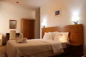 une chambre avec un grand lit avec des oreillers blancs dans l'établissement Hotel Belém Tejo - Setubalense, à Lisbonne