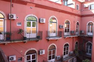 czerwony budynek z oknami i balkonami w obiekcie Belém Tejo - Setubalense w Lizbonie