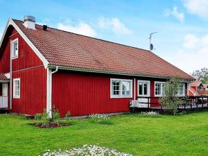 a red barn with a red roof on a green field at 5 person holiday home in LAMMHULT SVERIGE in Förhult