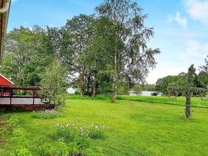 Förhultにある5 person holiday home in LAMMHULT SVERIGEの赤い建物と木々のある緑草原