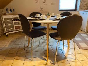 a table with four chairs around it in a kitchen at Cozy Apartment in Merlsheim with Garden in Nieheim