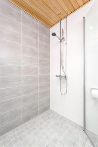 a shower stall in a bathroom with a tile floor at Trendy Homes Oulu Apartments in Oulu