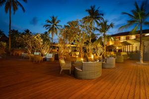 a patio with chairs and trees in front of a building at Cinnamon Bentota Beach - Signature Selection in Bentota