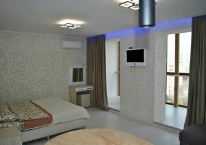 a bedroom with a bed and a tv on a wall at apart-hotel Sky in Yuzhne +118 photos