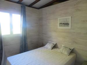 a bedroom with a large bed with a window at Bungalow des Palétuviers in Morne-à-lʼEau