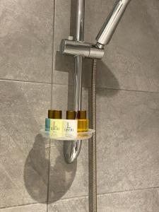 une barre métallique avec trois bouteilles sur une étagère sur un mur dans l'établissement Liberi Hotel Taksim, à Istanbul