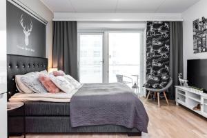 a bedroom with a bed and a large window at Trendy Homes Oulu Rautatienkatu in Oulu