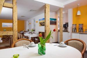 a dining room with a table with a vase of flowers on it at Hotel Beck in Lauscha