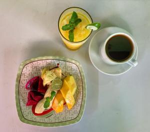 a plate of fruit next to a cup of coffee at Lembongan summer in Nusa Lembongan