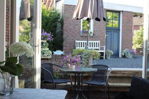 a patio with a table and chairs and an umbrella at Slapen & Smullen in Swalmen
