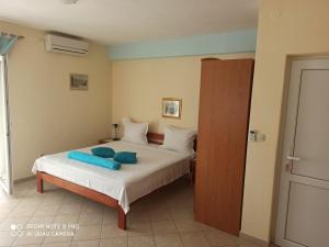 a bedroom with a bed with blue pillows on it at Apartments Ana in Grebaštica