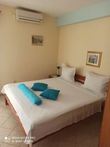 a bedroom with a large white bed with blue pillows at Apartments Ana in Grebaštica