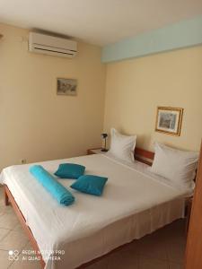 a bedroom with a large white bed with blue pillows at Apartments Ana in Grebaštica