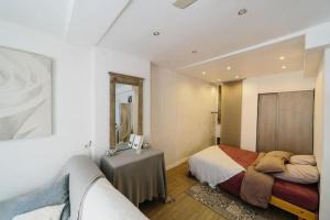 a bedroom with two beds and a table and a mirror at Studio tt équipé parking cœur ville in Sanary-sur-Mer