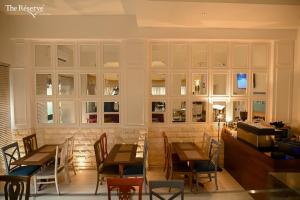 a restaurant with wooden tables and chairs and windows at The Reserve Boutique Hotel in Karachi