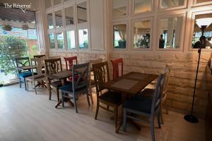 a restaurant with wooden tables and chairs and windows at The Reserve Boutique Hotel in Karachi