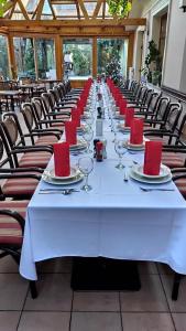 uma mesa longa com guardanapos vermelhos e copos em Publo Étterem és Panzió em Csákvár