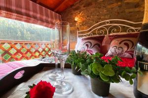 a table with two wine glasses and flowers on it at Mortazel River Houses in Montazel