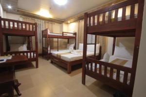 a room with three bunk beds and a desk at Monte casa de Rico in Vigan