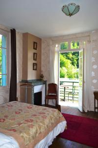 a bedroom with a bed and a fireplace and a window at Maison Esmeralda Chambres D'Hotes et Gite in Biert