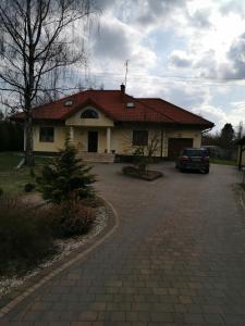 una casa con un coche aparcado en una entrada en Willa na Jurze, en Zarki Letnisko