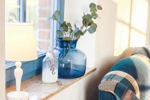 a blue vase sitting on a window sill with a plant at Ferienwohnungen Ostseestern in Rakow