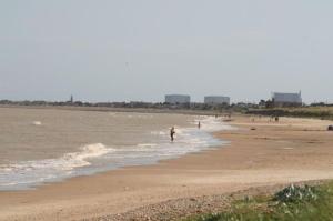 a group of people walking on the beach at Beautiful Spacious Holiday Home - Romney Sands in New Romney